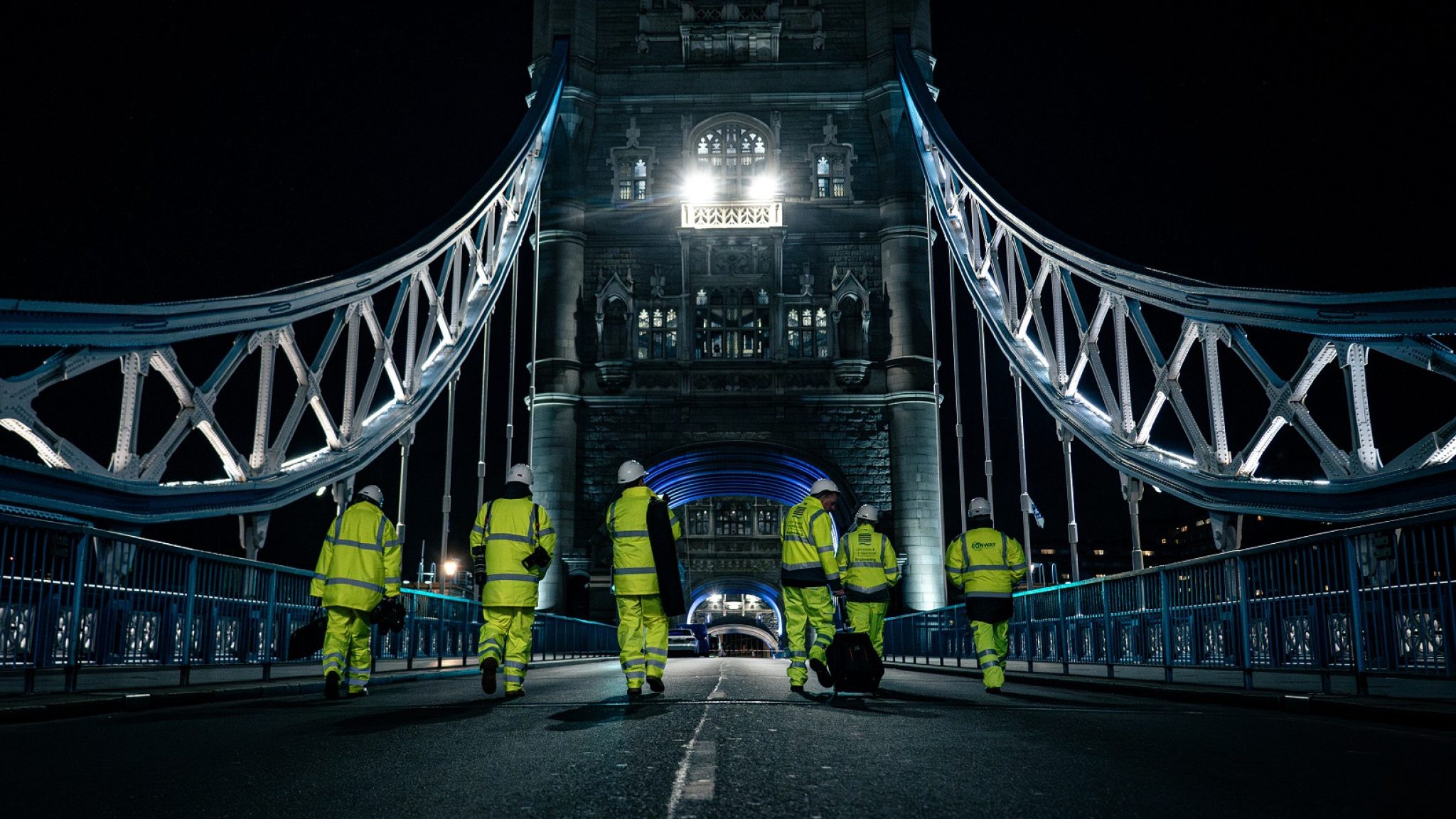 Night workers walking along the bridge deck at Tower Bridge